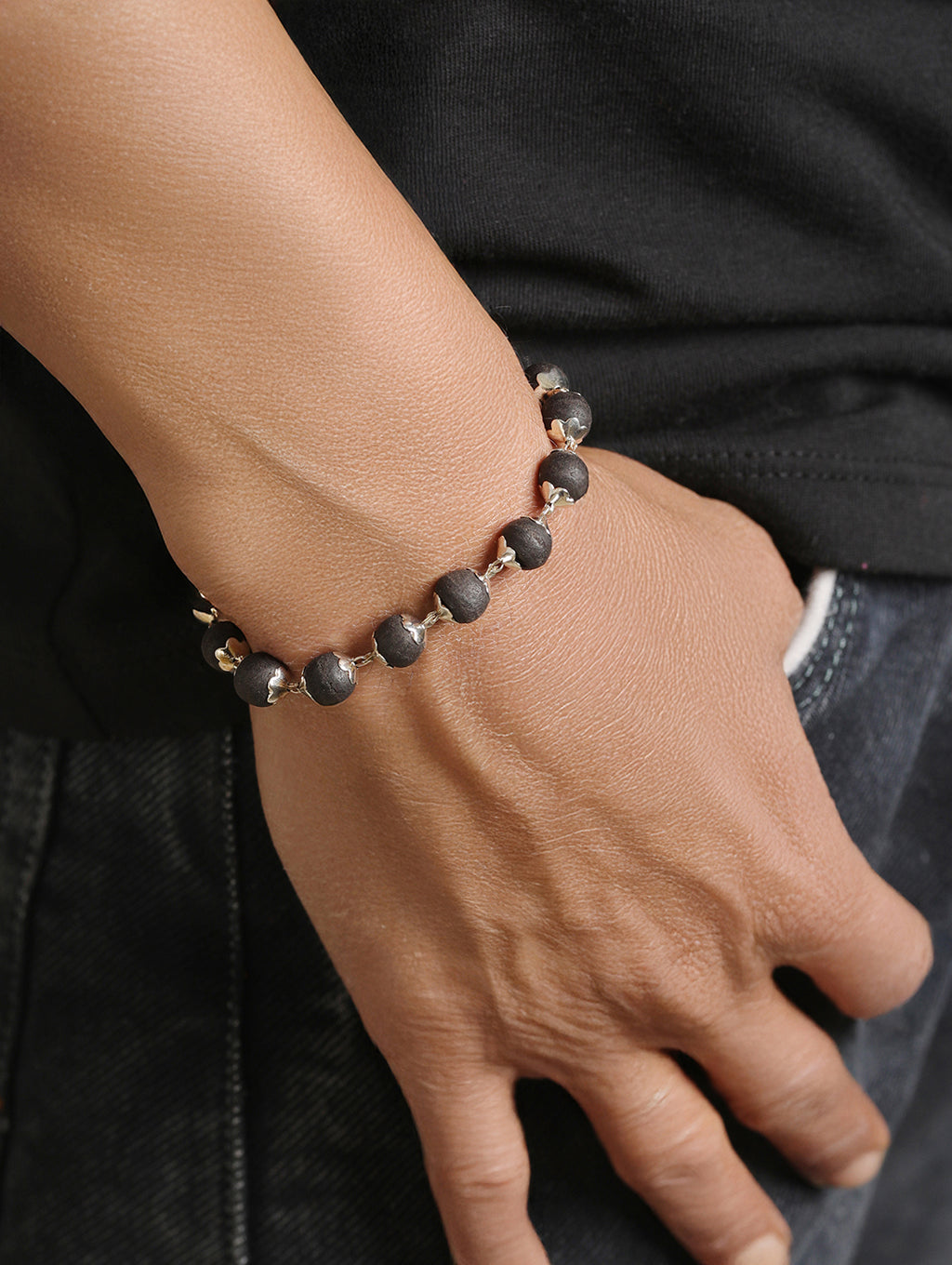 Man wearing Karungali black wooden beaded bracelet with casual outfit